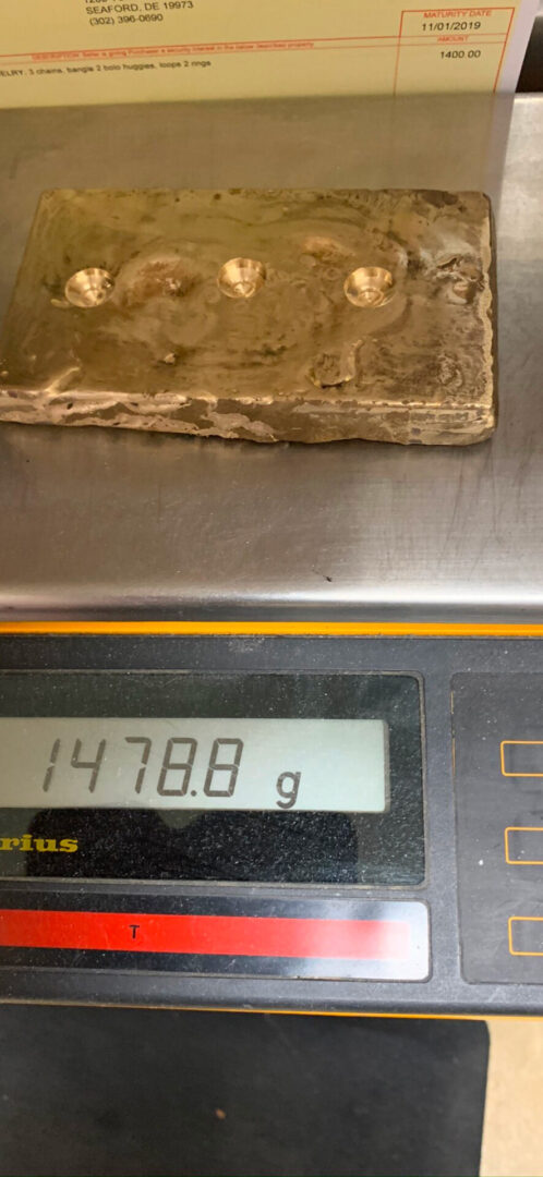 Gold bar on a scale weighing 1478.8 grams.